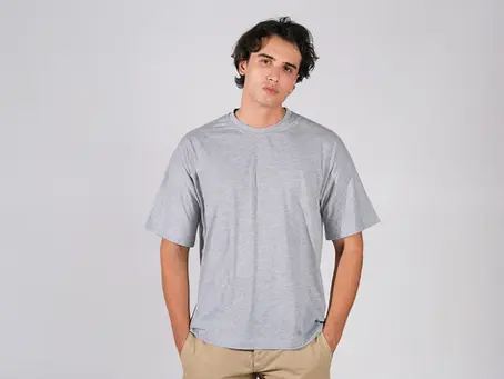 Bafaco Tekstil üretimi melanj gri, oversize kesim baskısız tişört giyen erkek model