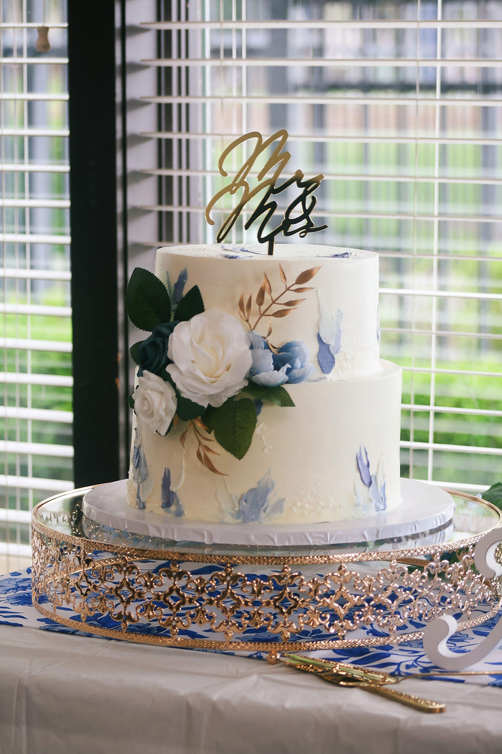 Elegant white and blue wedding cake with floral topper by AJ’s Sweet Creations Prosper TX