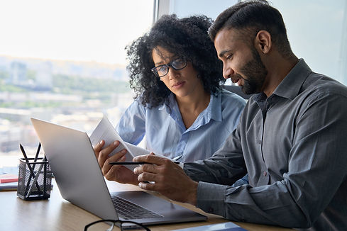 Pair of colleagues reviewing documents in an office.