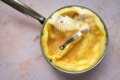 nadýchaná omeleta na pánvi přiklopená poklicí