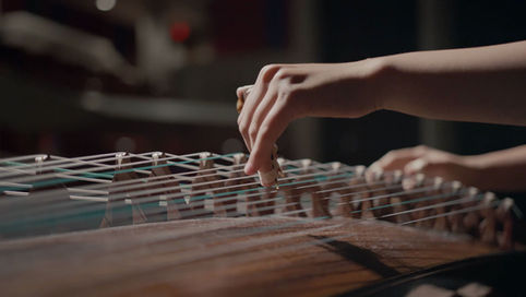 close up shot of hands playing Chinese instrument