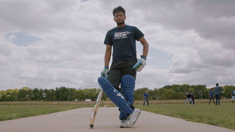 UIS student poses for portrait wearing cricket gear