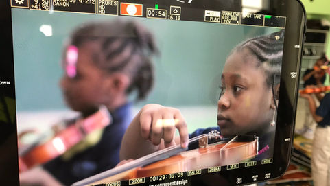 Close up of monitor watching MUSIC Inc students