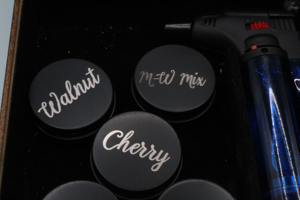 Thumbnail: shows the black round tins that store the wood chips with the engraved label on the lid