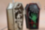 Thumbnail: Two decorative coffin-shaped boxes featuring intricate cutouts, one with spiderweb and skeletal hand motif.