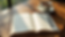 Eye-level view of a journal open on a wooden table with a pen and a cup of tea