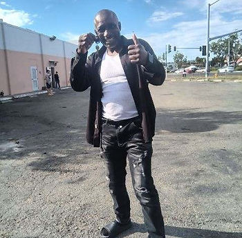 An excited and happy man standing in a parking lot holding keys to his new home