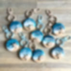 A group of personalised ocean keyrings in a lovely shade of pastel blue and beige.