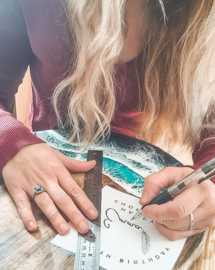 A woman in the process of engraving on to a cutting board.