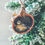 Thumbnail: A bluetit decoupage shell is hung on a branch of a Christmas tree.