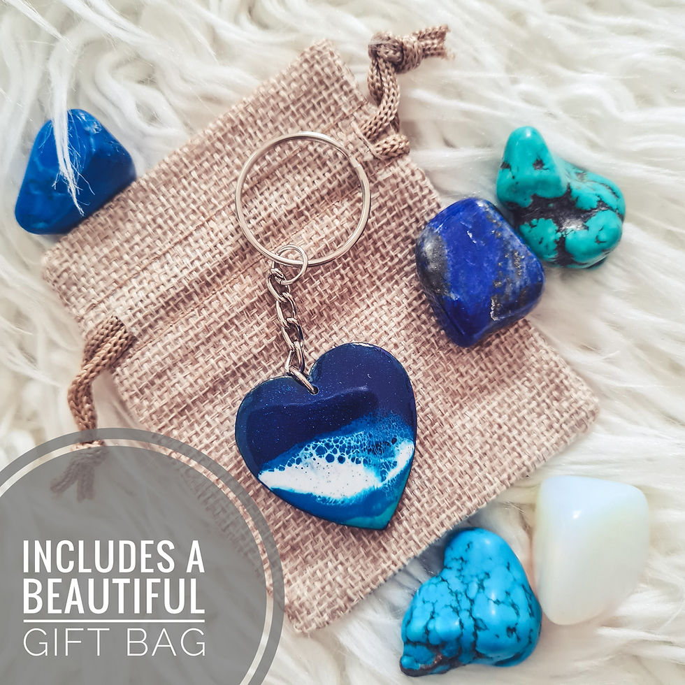 Thumbnail: A keyring with an ocean resin heart design placed atop a hessian gift bag.