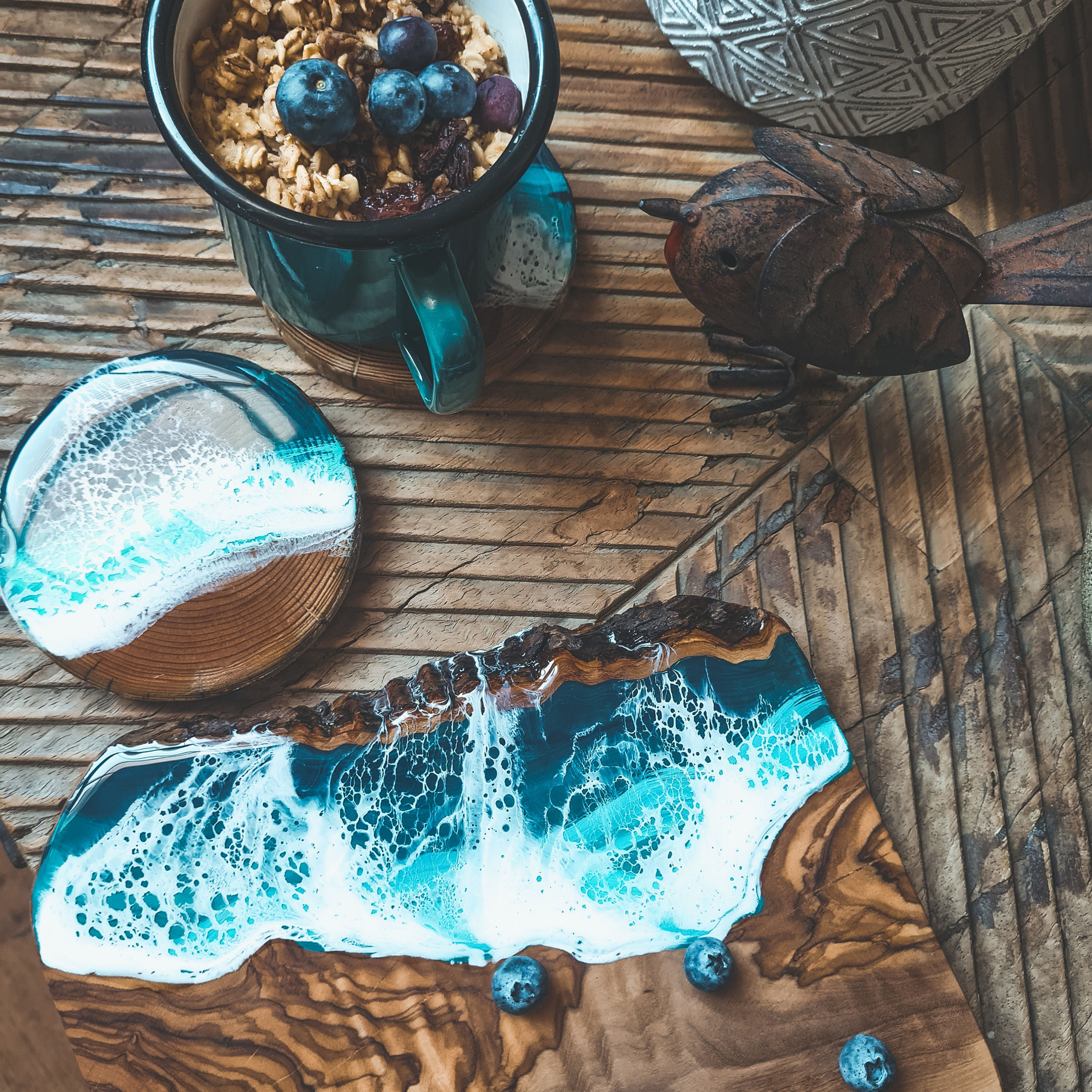 Ocean resin coasters and ocean resin olive board with a mug of oatmeal and berries.