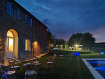 Evening view of a house with a pool and outdoor seating area