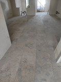 Interior room with tiled floor, unfinished walls, and natural sunlight coming through.