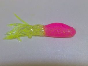 A shad tube with a pink body and chartreuse skirt