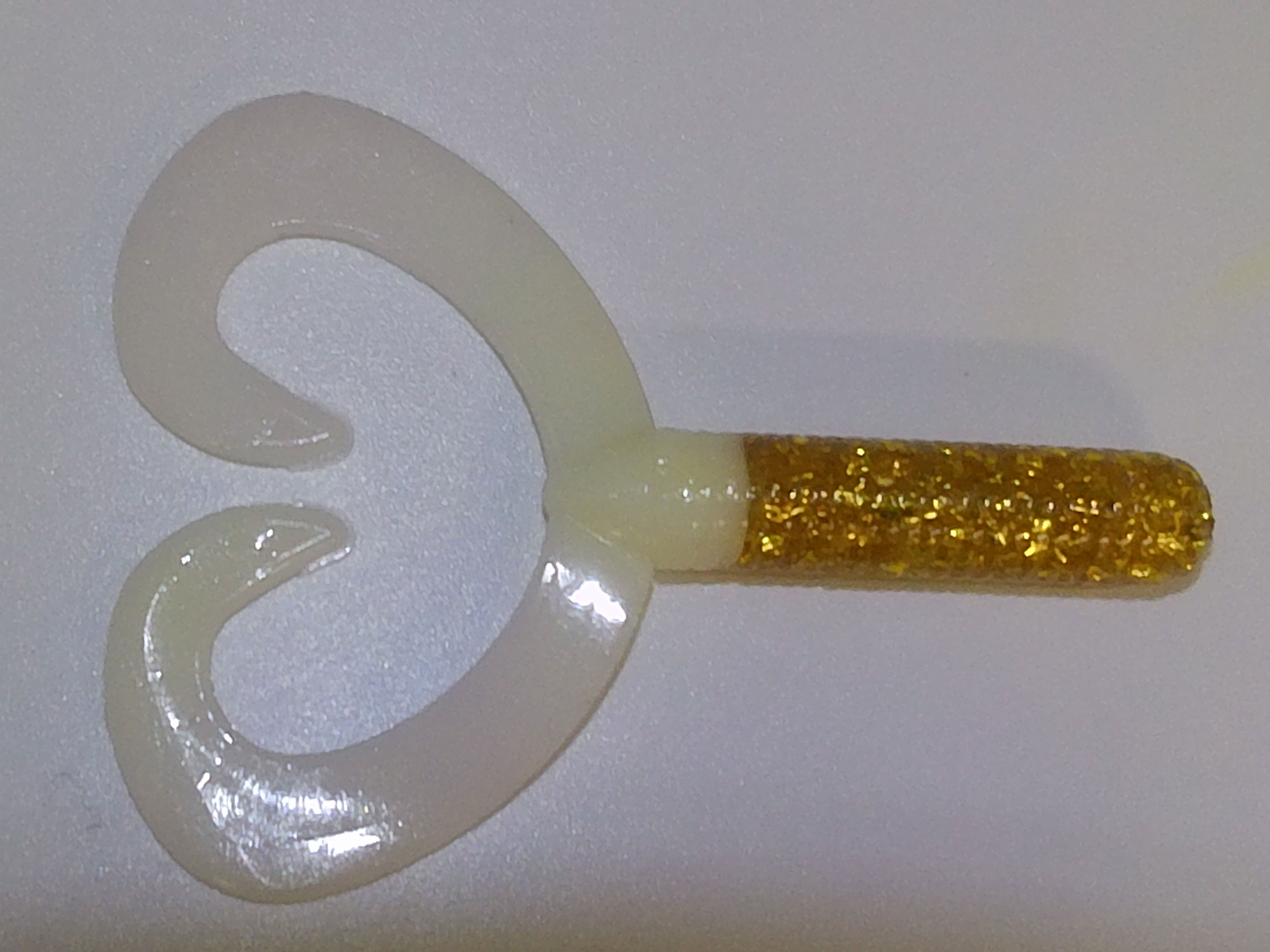 fishing lure with white tails gold body