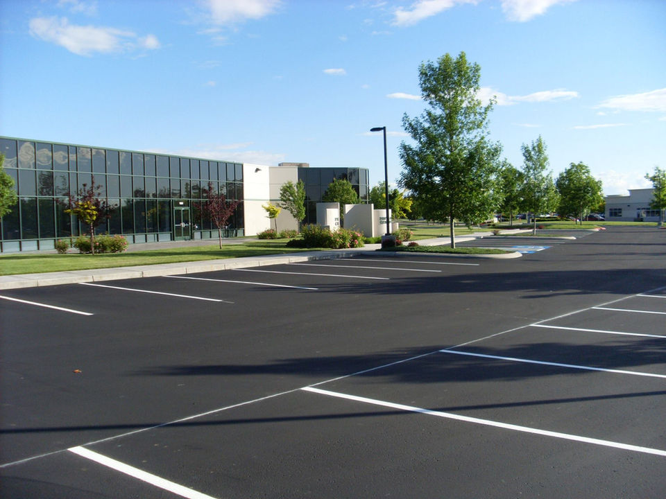 Empty parking lot next to a modern office building