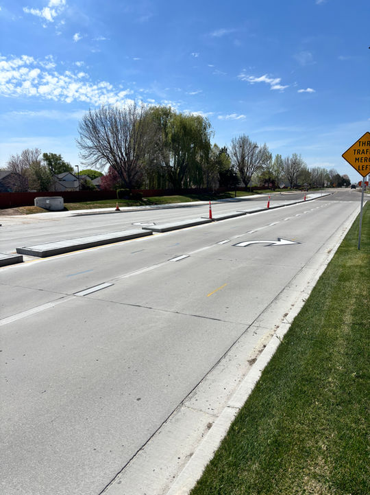 Newly paved road with concrete barriers and cones