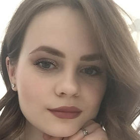 Ekaterina Solunya, junge Frau mit roten Lippen, buschigen augenbrauen, dunkelblonden, offenen Haaren schaut in die Kamera, den Kopf auf die Hand gestützt, an der man Ringe sieht. Im Ohrt mehrere Ohrringe