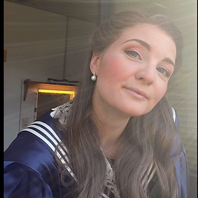 Anastasiya Taratorkina in costume of SOPHIE / Rosenkavalier mit long hair, pearl earings and a blue white sailors dress in her dressing-rrom