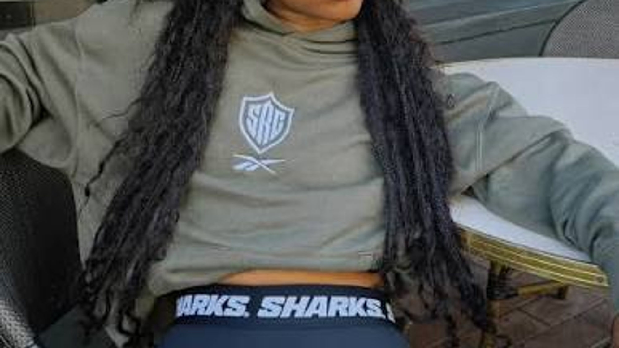 Model in an olive Sharks cropped hoodie and branded leggings