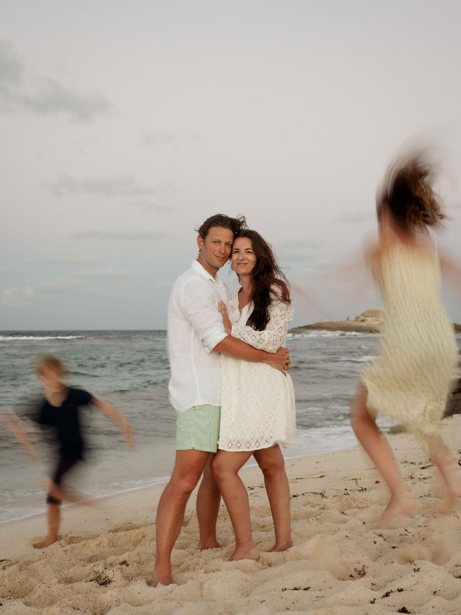 parents et enfant marchant sur une plage tropicale en Guadeloupe