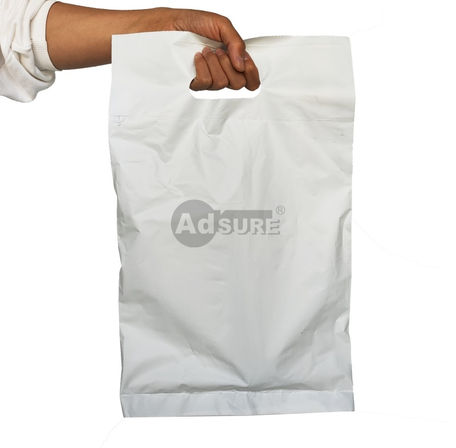 Hand holding a white opaque auto-bag with a reinforced die-cut handle, demonstrating easy carrying for retail and e-commerce orders.