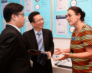 Business discussion between Adsure representatives and European partners regarding custom packaging solutions at exhibition.