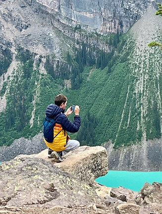 Jonathan taking nature photo from precipice over water