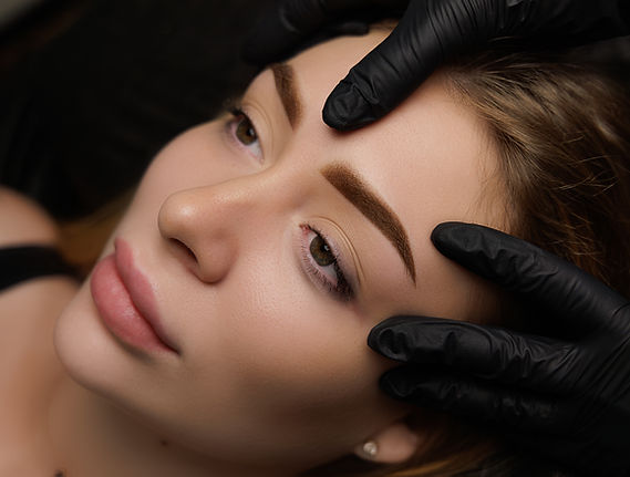 Photo of a girl after the procedure of permanent makeup, the master demonstrates the girl'