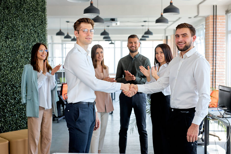 caucasian-young-business-people-co-workers-colleagues-greeting-each-other-shaking-hands