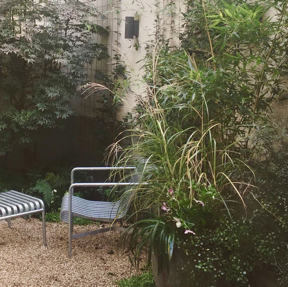 Assise Hay intégrée dans un jardin paysager parisien aux plantations naturelles