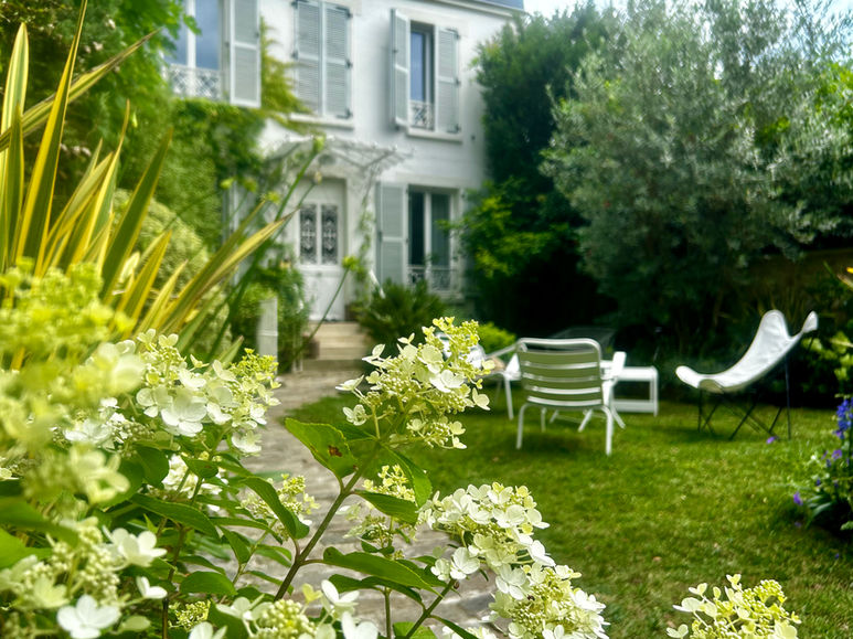 Détail de floraison blanche au premier plan dans un jardin de ville