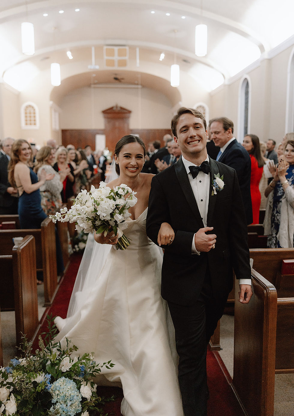 a bride and groom walking down aisle