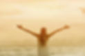 woman-with-raised-arms-at-sunset-on-the-
