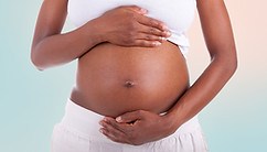 very pregnant woman with hands on her belly