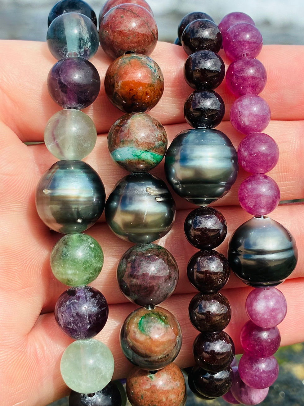 Close-up of four strands: Tahitian Pearl & Gemstone Bracelet colorful beads visible.