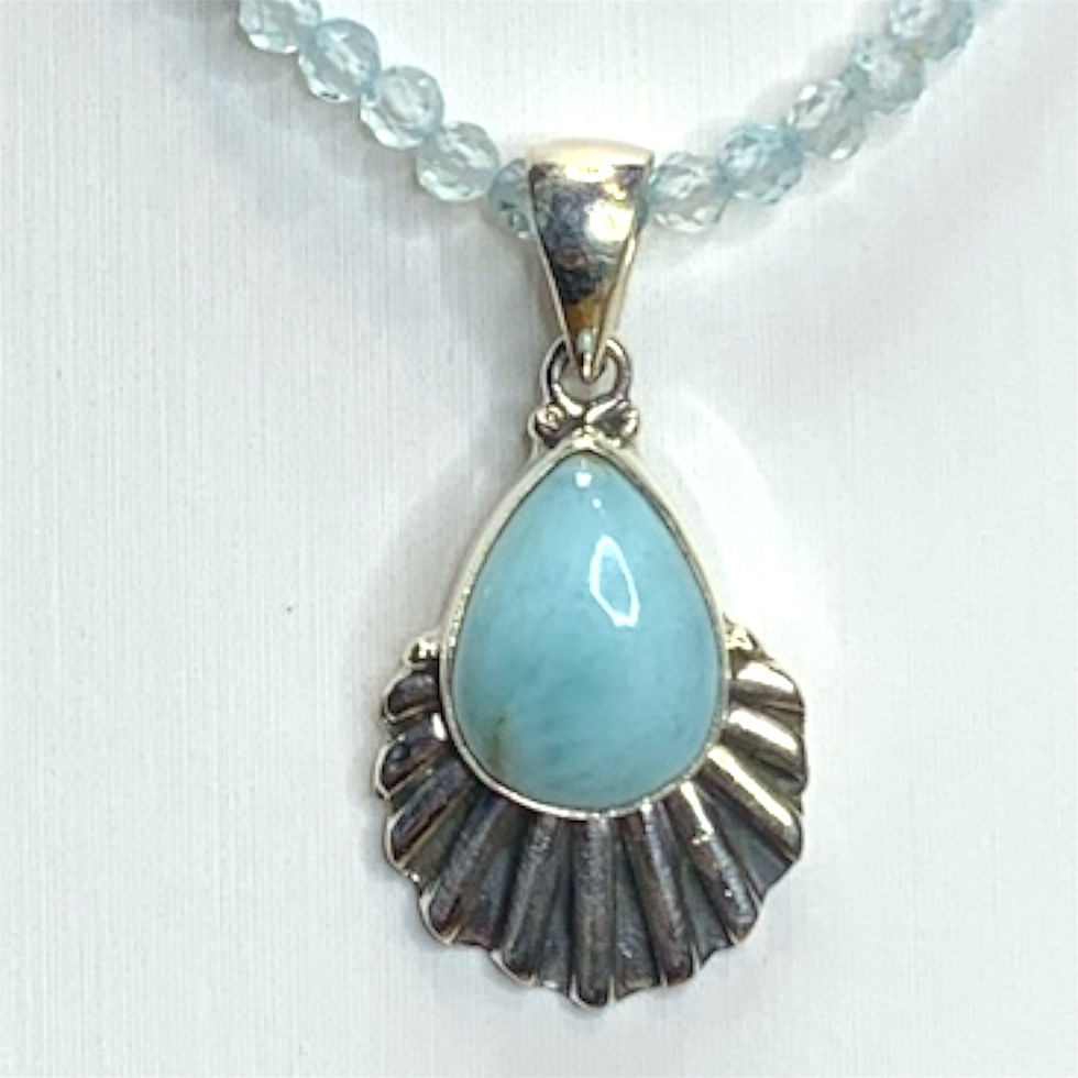 Silver pendant with blue larimar gemstone on light blue topaz beads, close up shot