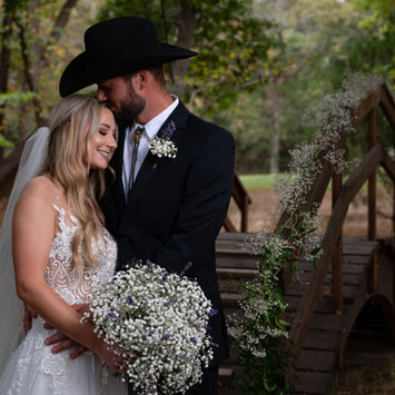 Newlyweds embracing on a wooden bridge
