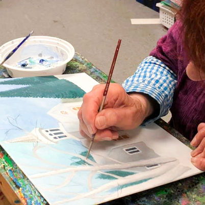 Adult working on a painting in class at Artichoke Art Studio.