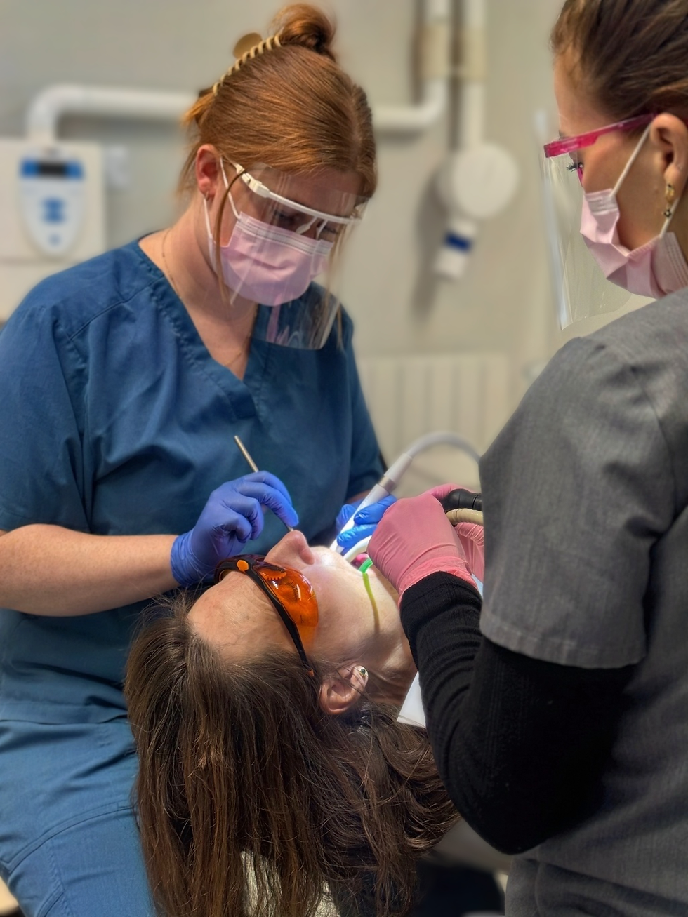 Dental hygienist performing a cleaning on a patient.