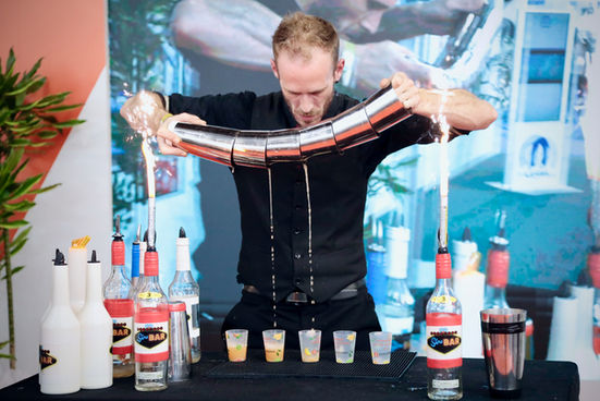 Flair bartender réalisant un show cocktail avec shaker et étincelles lors d’un événement