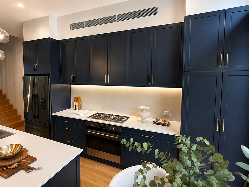 Coogee NSW kitchen renovation with navy Shaker cabinetry, brass hardware and light stone finishes