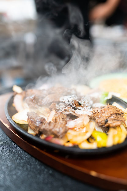 steaming steak fajita platter with onions and peppers