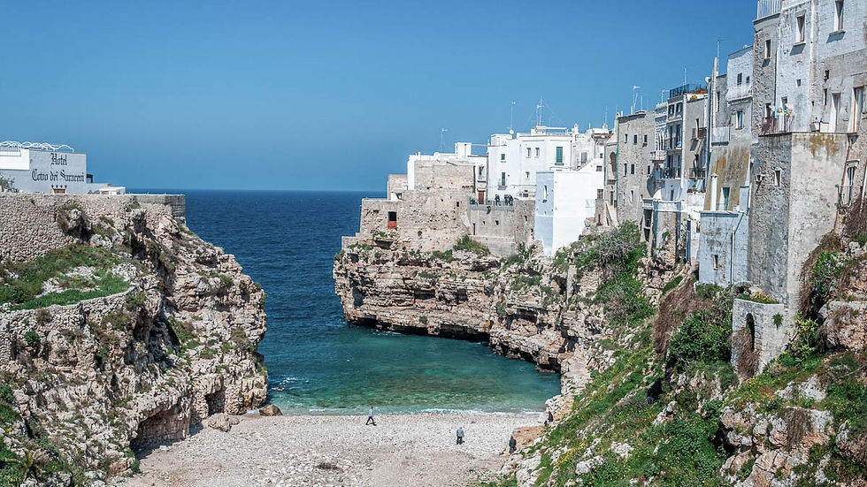 Polignano a Mare in Puglia with cliffside houses above a rocky beach and turquoise sea