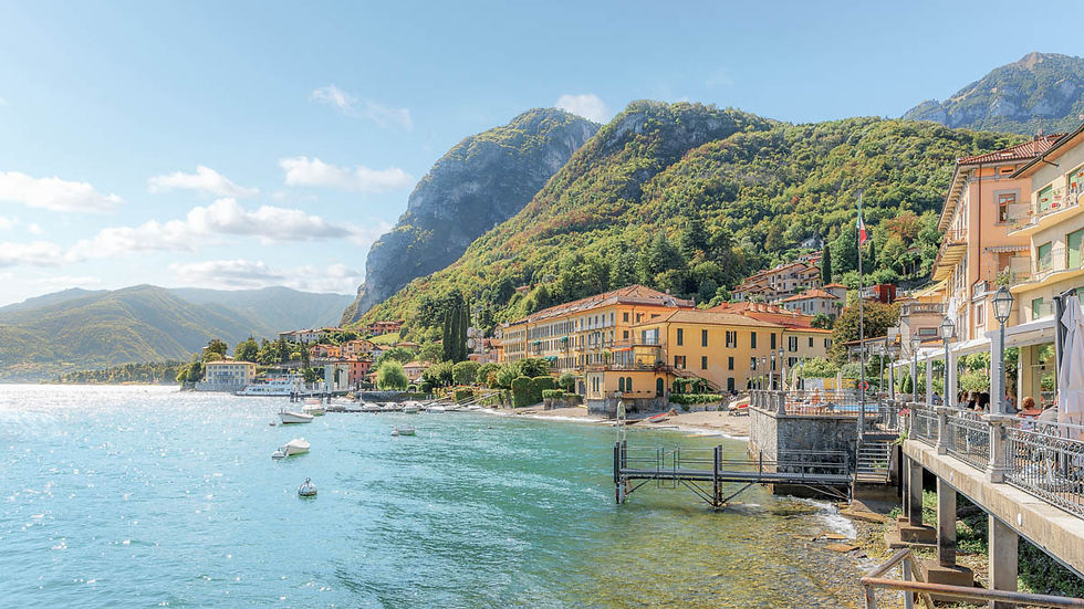 Menaggio waterfront on Lake Como with boats, mountains, and lakeside hotels