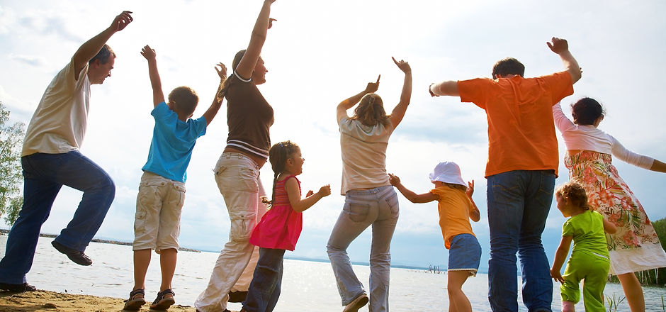 Big family from  adults and children dancing on the beach.jpg
