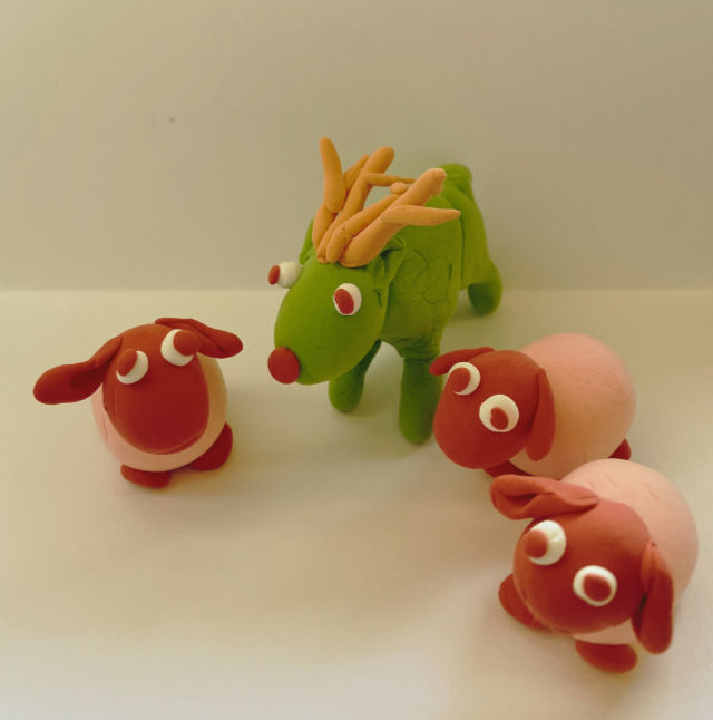 Modelling clay deer in a field of modelling clay sheep.