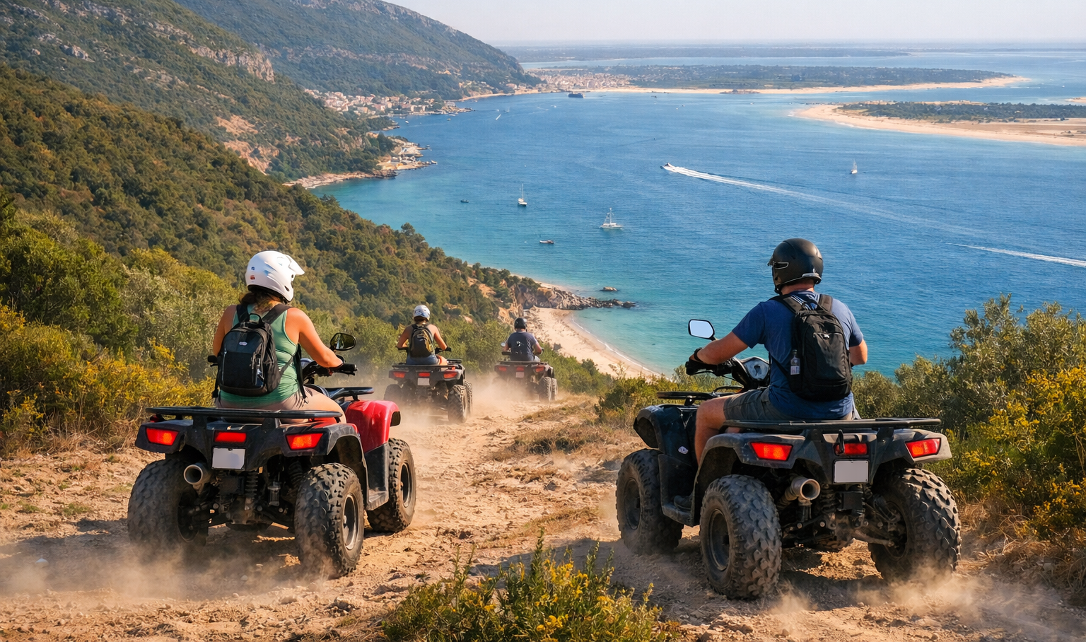 ATV riders descend a dusty hillside trail above a blue bay and sandy coast, with boats in the water below.