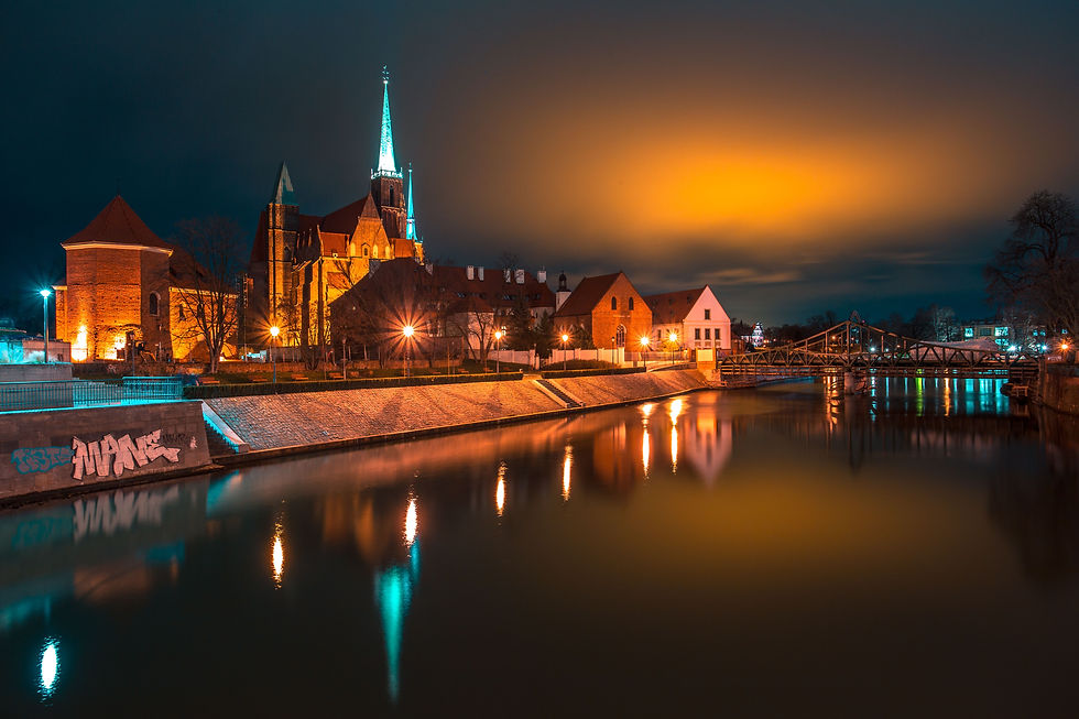 Oder River at night in Wroclaw Poland with illuminated Cathedral of St John the Baptist and Old Town buildings reflecting in water - evening walk along Oder River Wroclaw